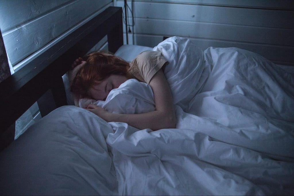 woman sleeping in a bed with covers